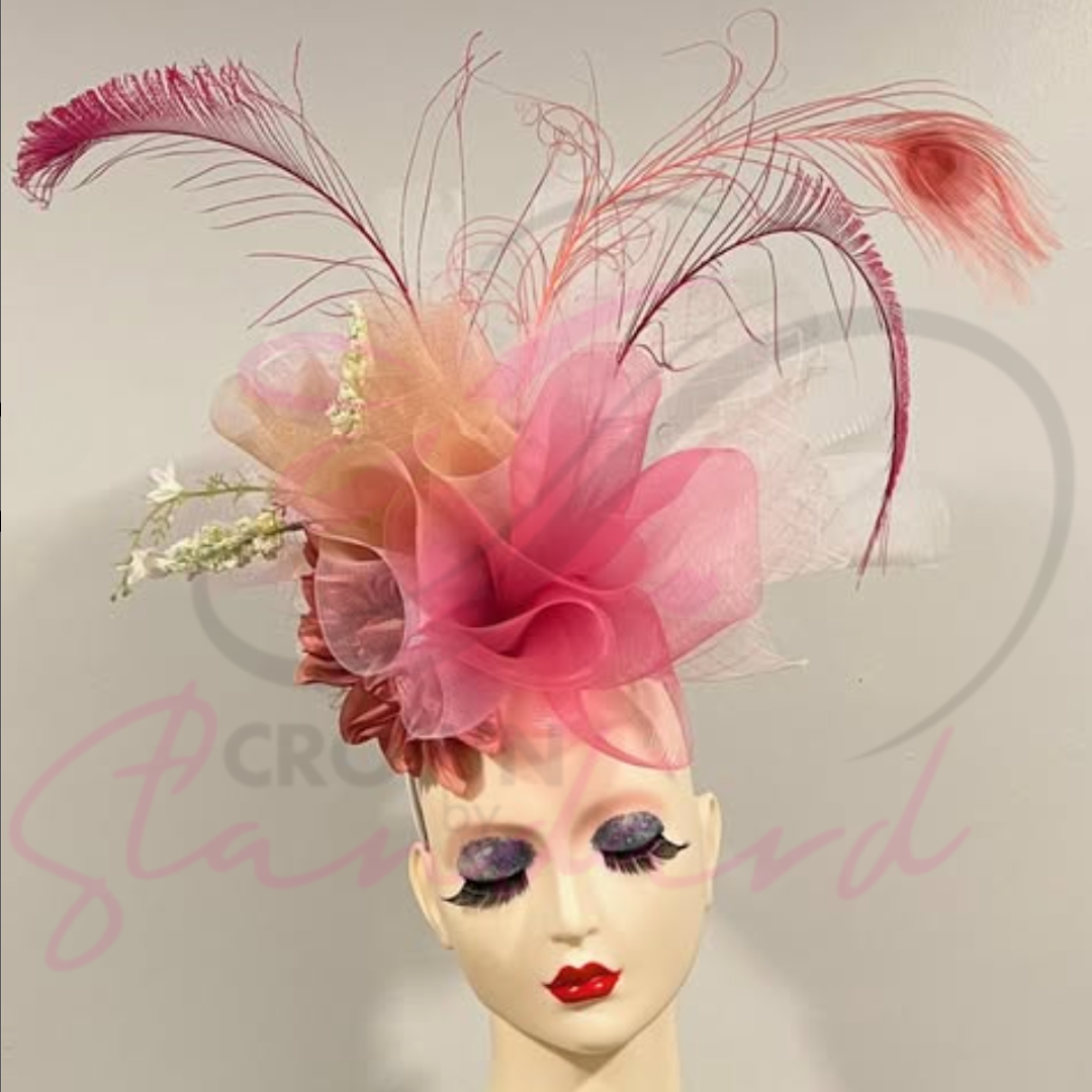 This fascinator has white, light pink, pink, and peachy orange colors with feathers and a flower!