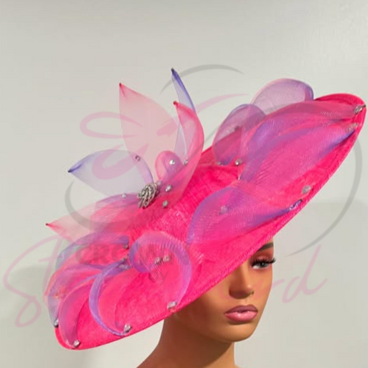 Pink fascinator features a swirl of lavender and pink crinoline, accented with a button and sparkling embellishments.